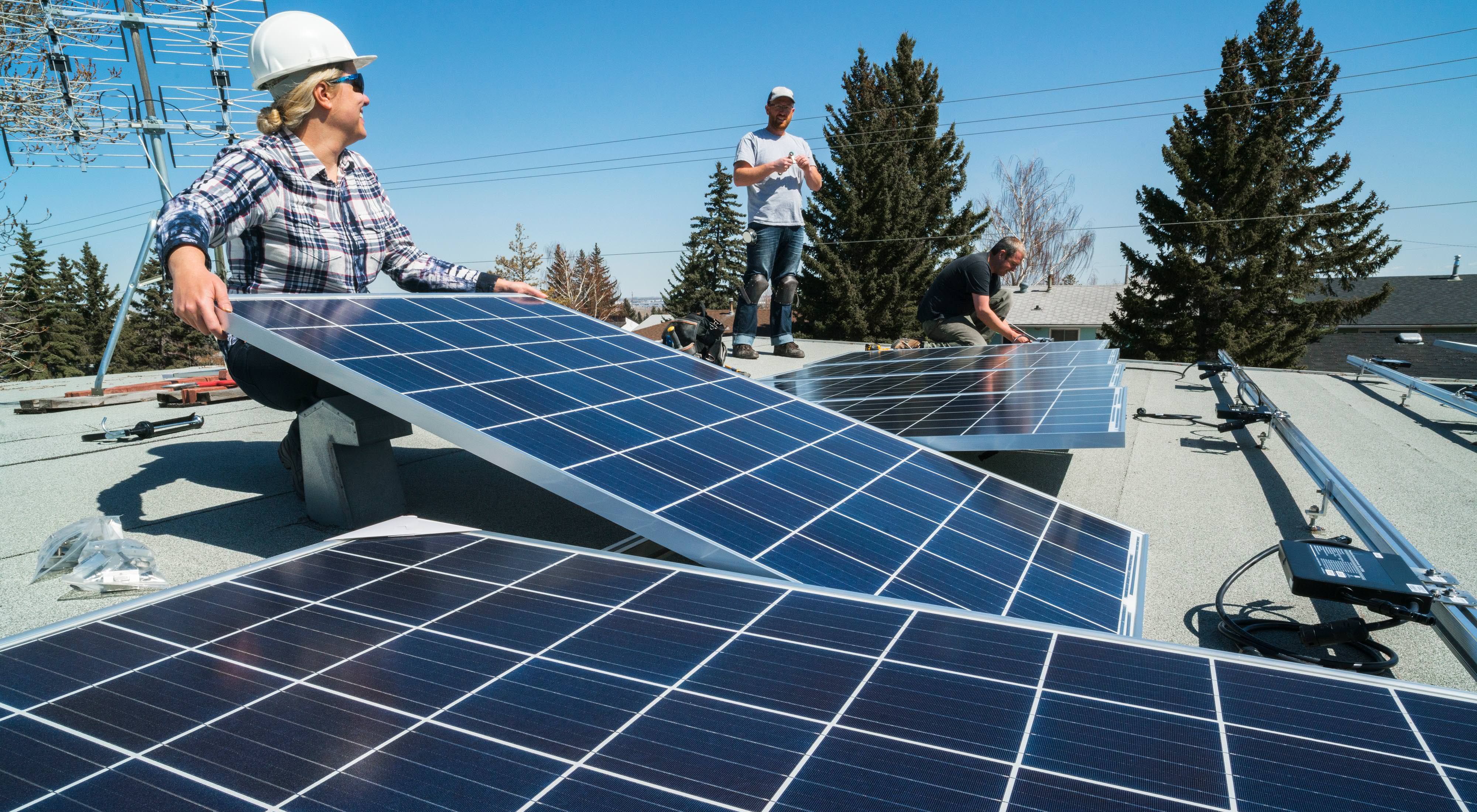 Workers installing solar panels on a residential homes roof.