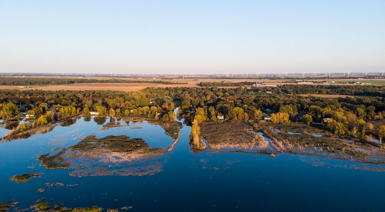 Aerial view of houses and forest along a bay.