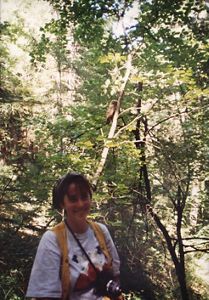 Samanth Horn smiling in a forest.