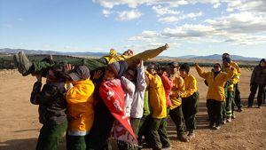 Fire workers do a trust exercise with a colleague.