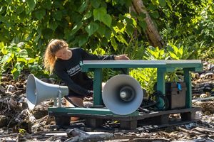 A person sets up a speaker playing mating calls over loudspeaker systems called seabird discotheques to entice birds to the atoll.