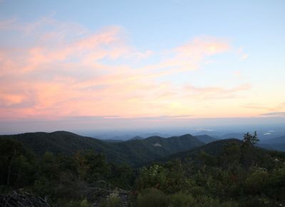 The sun sets over a mountain range.