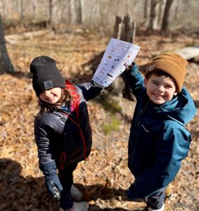 Two children hold up a piece of paper. 