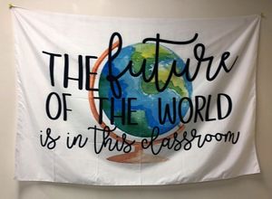 A white cloth banner with a picture of Earth says, 'The future of the world is in this classroom.'