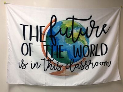 A white cloth banner with a picture of Earth says, 'The future of the world is in this classroom.'