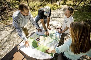 Four people examine a map at Dupree Nature Preserve in Kentucky.