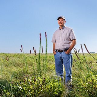 David Bezanson stands in a grassy field.