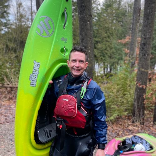 Man standing outside with a kayak.