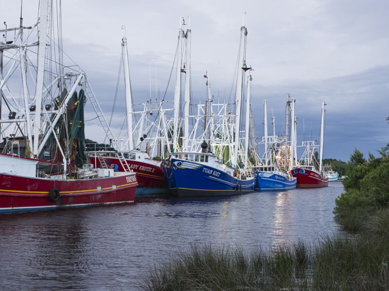 Colorful boats line up along a waterway.