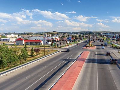 Aerial view looking down a main road in Gillette, Wyoming, with gas stations and other commercial buildings sited alongside the road.