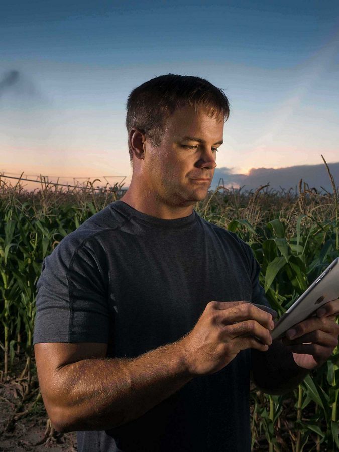 man with tablet in cornfield center pivot irrigation