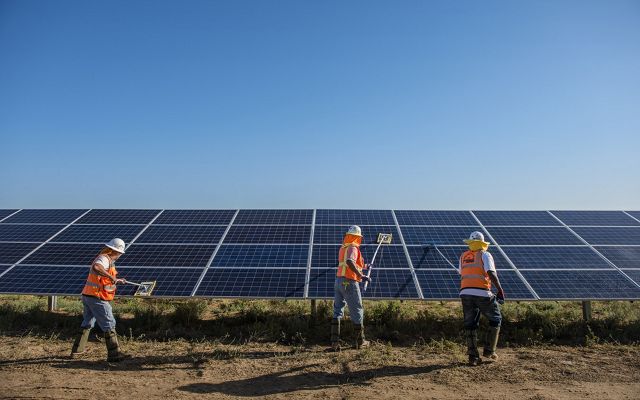 Workers clean solar panels for maximum efficiency at the power solar facility in Lancaster, California.
