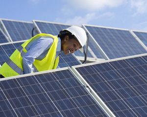 Electrical engineer woman checking solar photovoltaic panels on the roof of a solar farm.