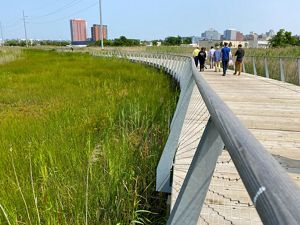People enjoy a walk along a boardwalk through South Wilmington's wetlands park.