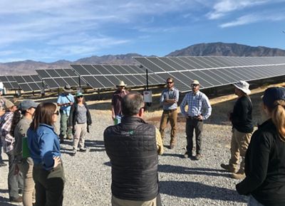 Group of people in discussion beside Nevada solar array