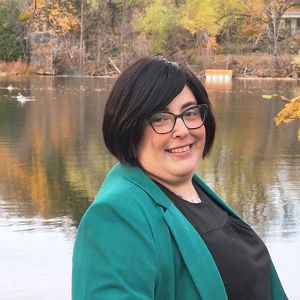 Person smiling in front of nature.