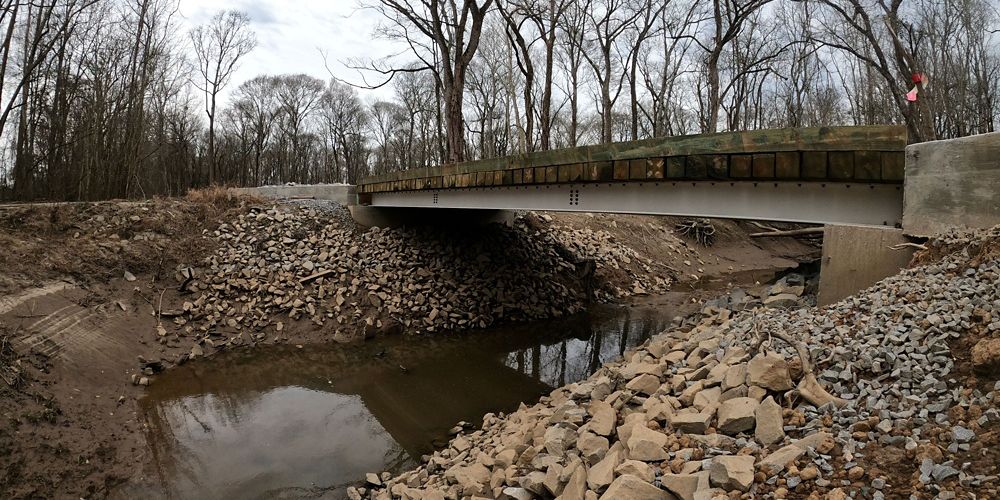 Fish-friendly bridge over a body of water. The bridge is big enough for cars to drive over.