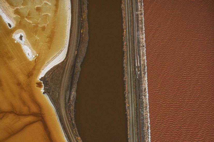 in a geometric image seen from above, pools of different brown hues are seen against each other with a dark stream running between them