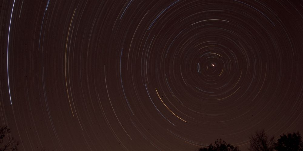 Stars swirl around in a nightsky.