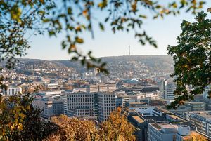 Vista panorámica de Stuttgart con edificios bordeada de colinas y vegetación.
