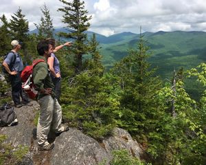 Three people standing atop Burnt Mountain in Vermont.