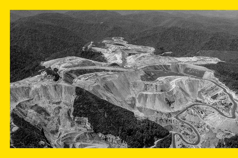 Black and white aerial photo of a mountaintop coal mine in West Virginia, showing degraded land surrounded by forest.