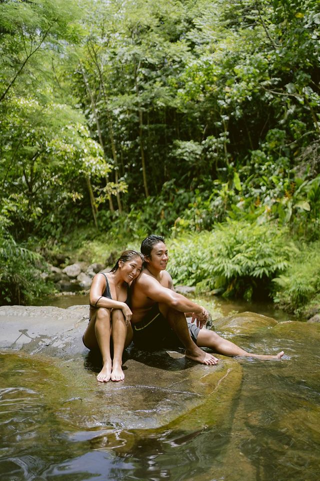Two volunteers relax next to He'eia Stream.