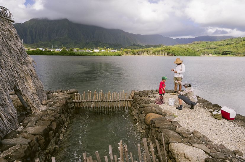 People fish in Kaneohe, Hawaii, on a community fishing day.