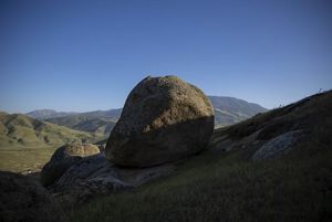Rock formations with sun and shadow against a blue sky.