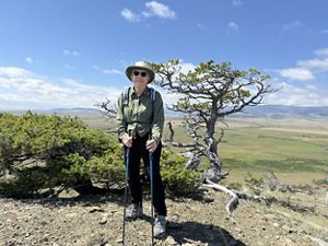 A woman standing on a hiking trail.