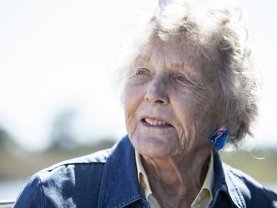 An elderly woman looks off in the distance.