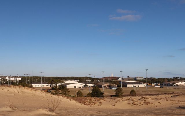 View to the Kill Devil Hill's school from a sand dune. Morning blue cloudless sky.