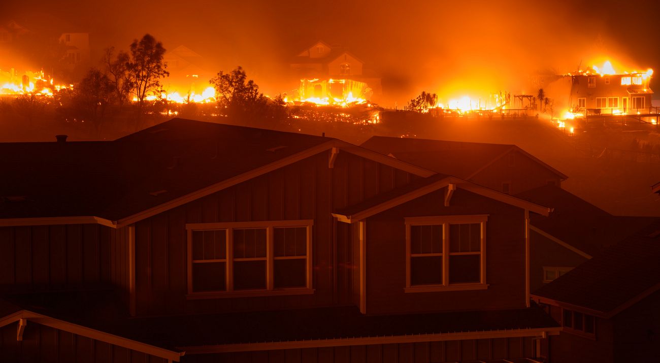 A house with a raging fire approaching.