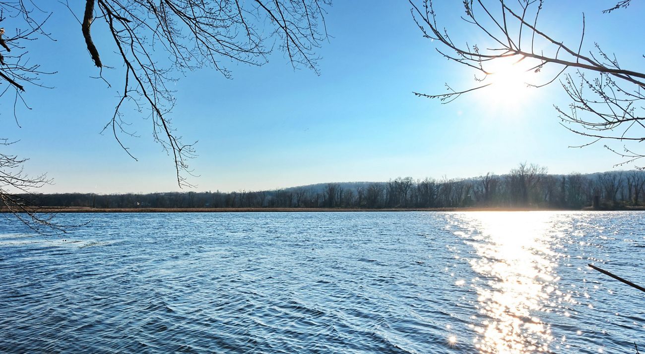 The sun sets over a large pond.