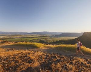 A woman hikes along the edge of Upper Table Rock in OR.