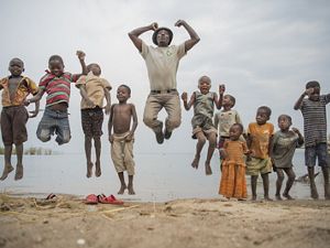 The Nature Conservancy's Peter Limbu plays with children next to Lake Tanganyika, Tanzania.