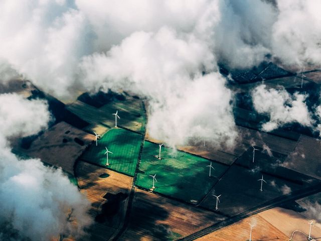 Aerial view of wind turbines on agricultural land.