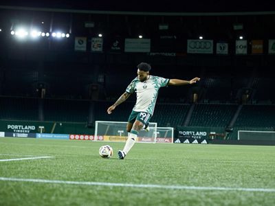 A person kicking a soccer ball.