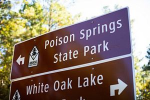A metal sign for Poison Springs State Park.