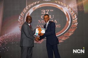 A man is presented an award on stage by another man.