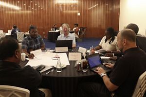 People sitting together at a table with computers in front of them as they discuss conservation.