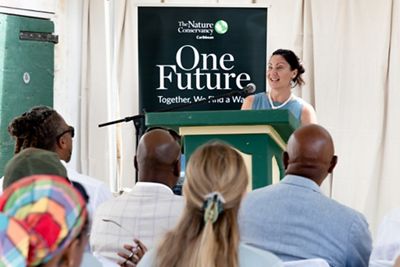 Jessica Ward stands and delivers a speech while at a podium at the Unplugging ceremony.
