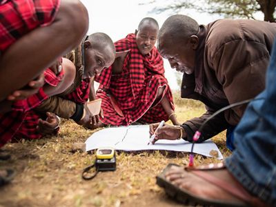 men writing on a map