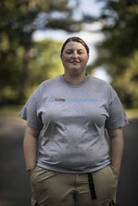 Lauren Kissel stands in a tree-lined road.
