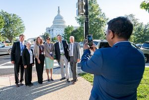 Person with phone takes picture of a group of people.