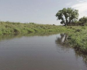 Aerial view of a comma-shaped oxbow next to the main channel of a river.