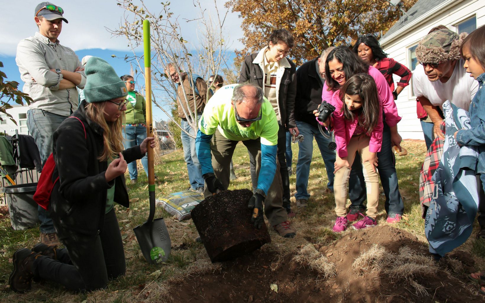 A group of people planting a tree.