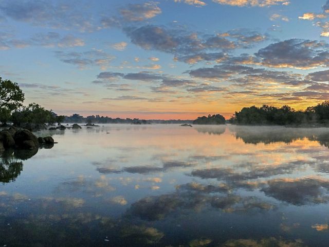 Sunrise over a foggy river.