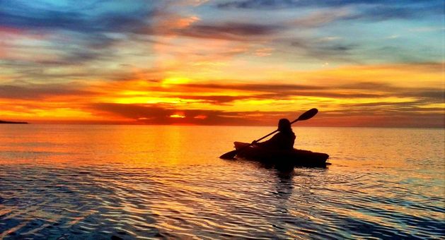 Sunset on Lake Superior silhouettes a solo kayaker.