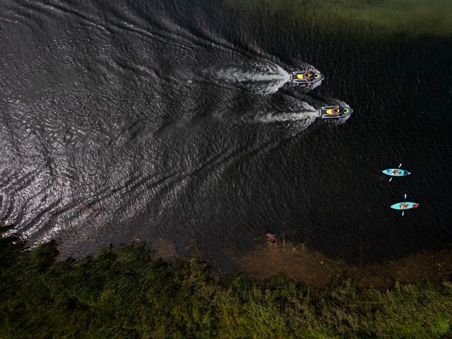 Aerial image of a pair of kayaks trailed by a pair of Jet Skis as they make their way north on the Torch River in northern Michigan